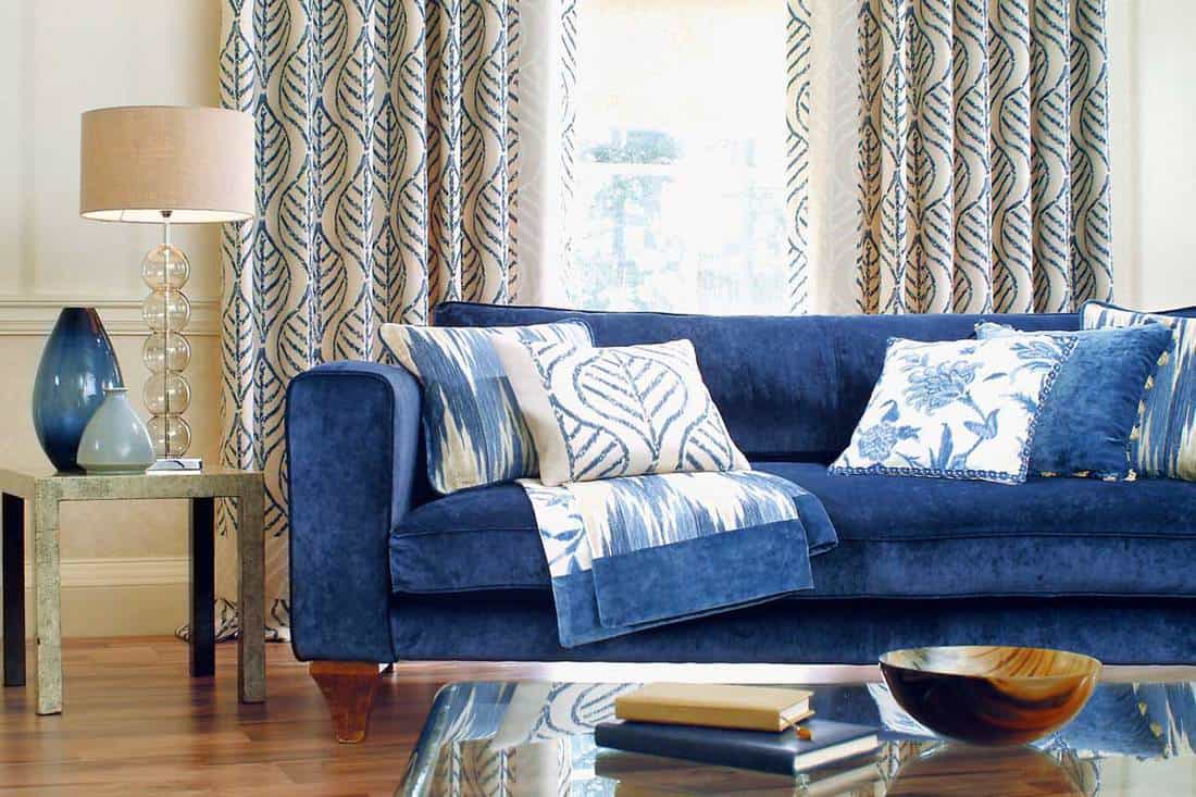 Blue sofa in a window on sunny day with table in foreground