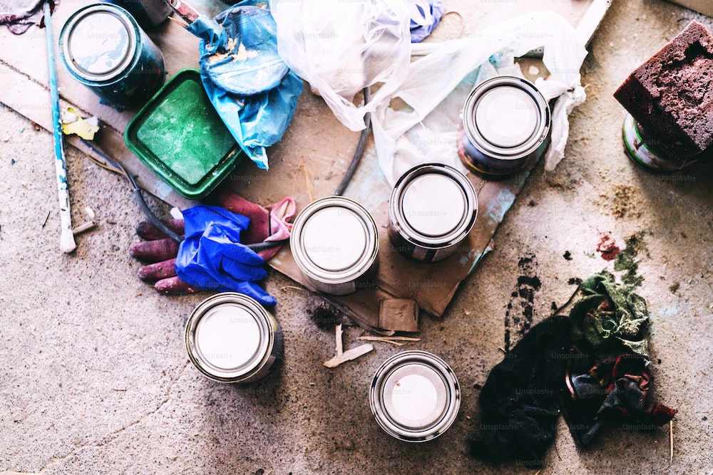 Small business of a young woman. Paint tin containers on the floor. Old furniture restoration.