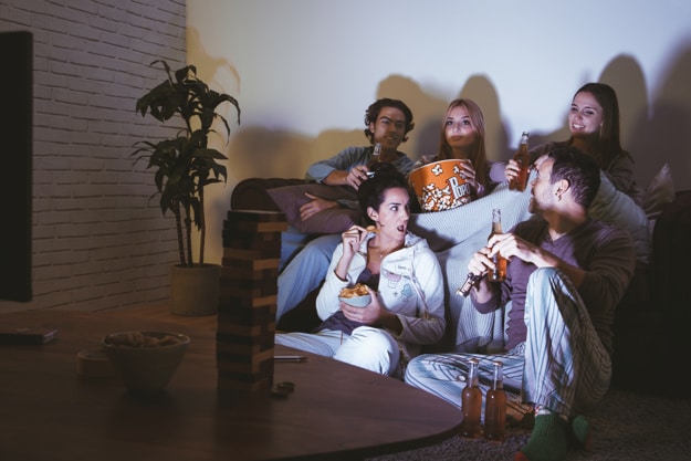 Friends enjoying a cozy Christmas Movie Night on a couch