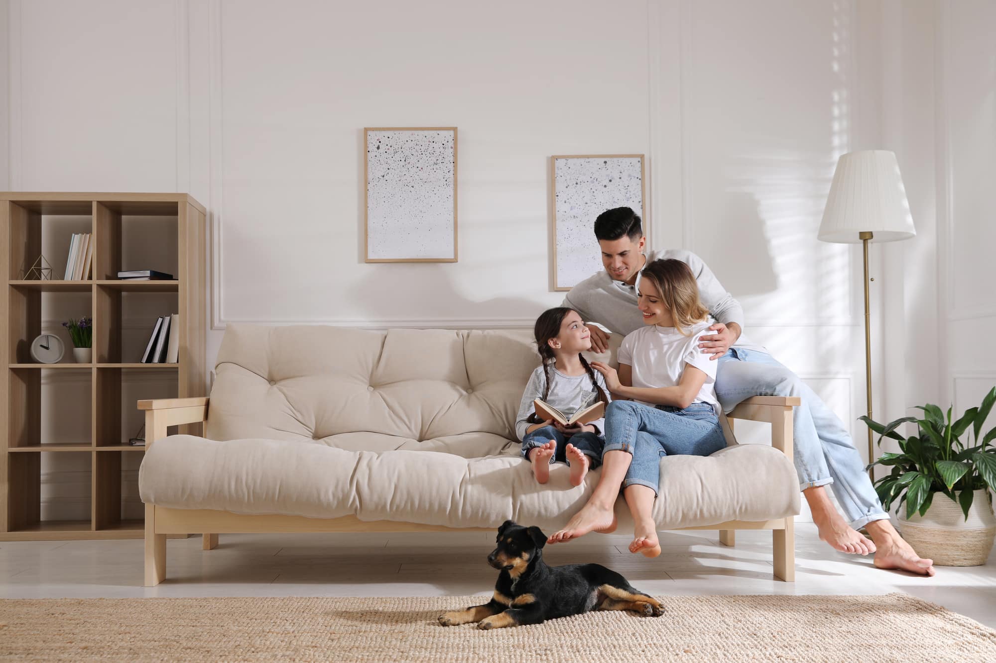 Happy family on sofa and puppy in living room