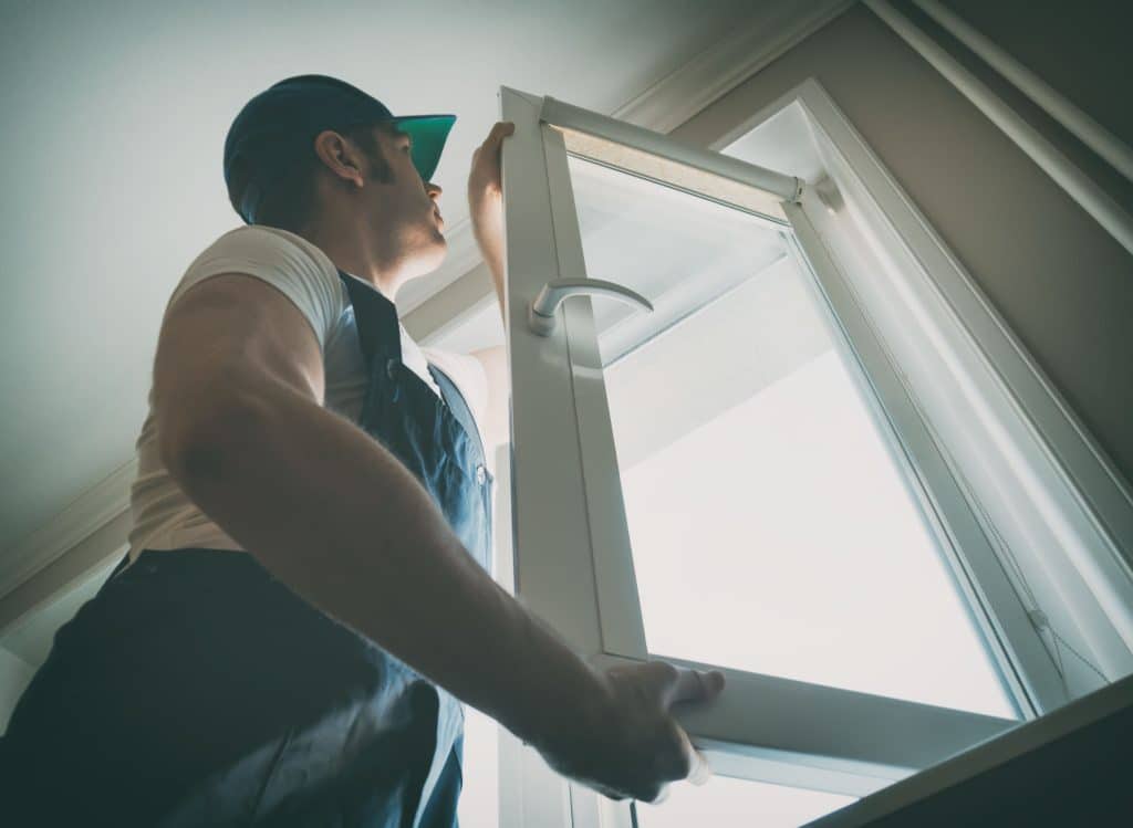 Professional handyman installing window at home.